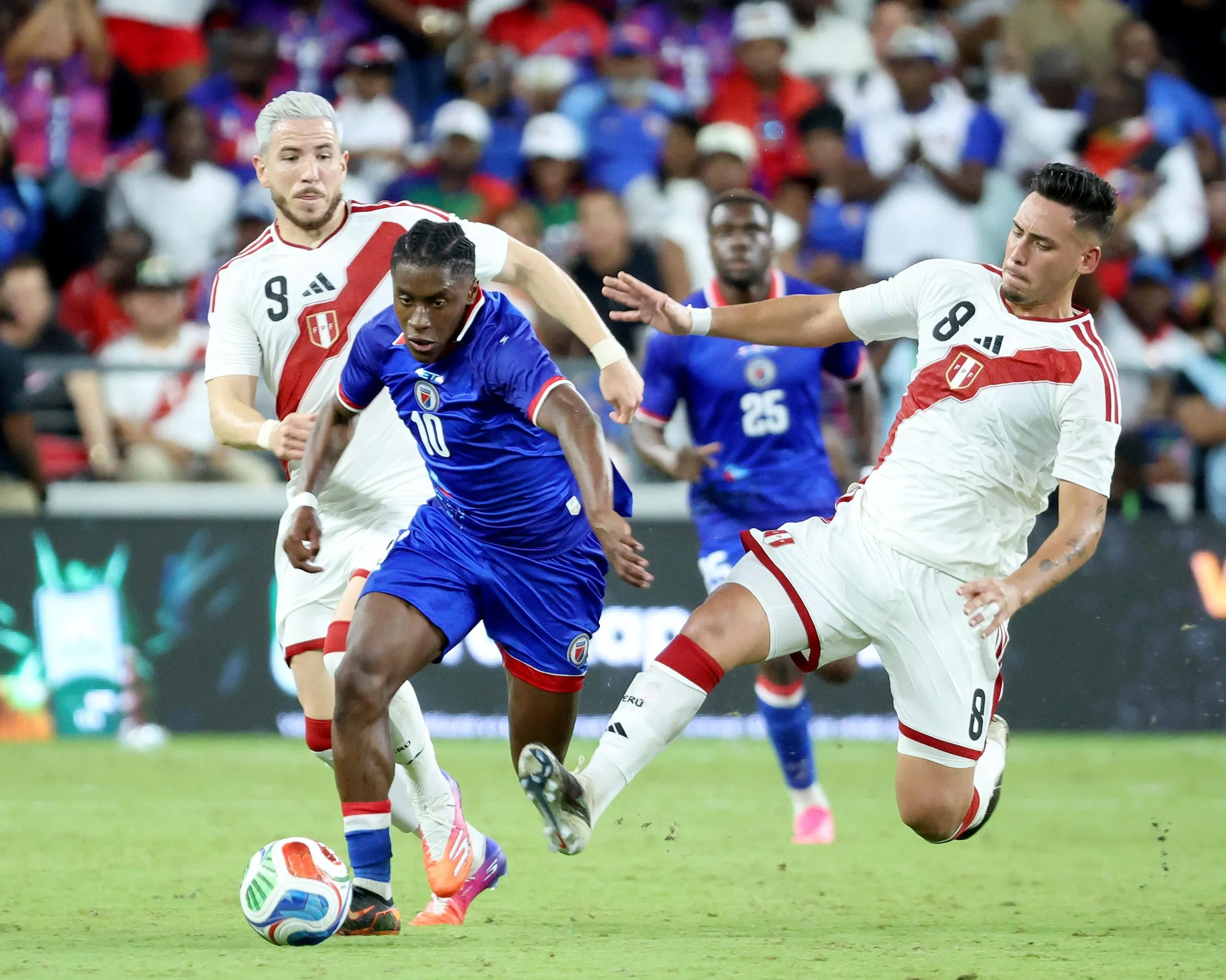 Jean-Ricner Bellegarde of Haiti fights for the ball against Adrian Ugarriza and Erick Noriega of Peru at Nu Stadium on June 5, 2026 in Miami